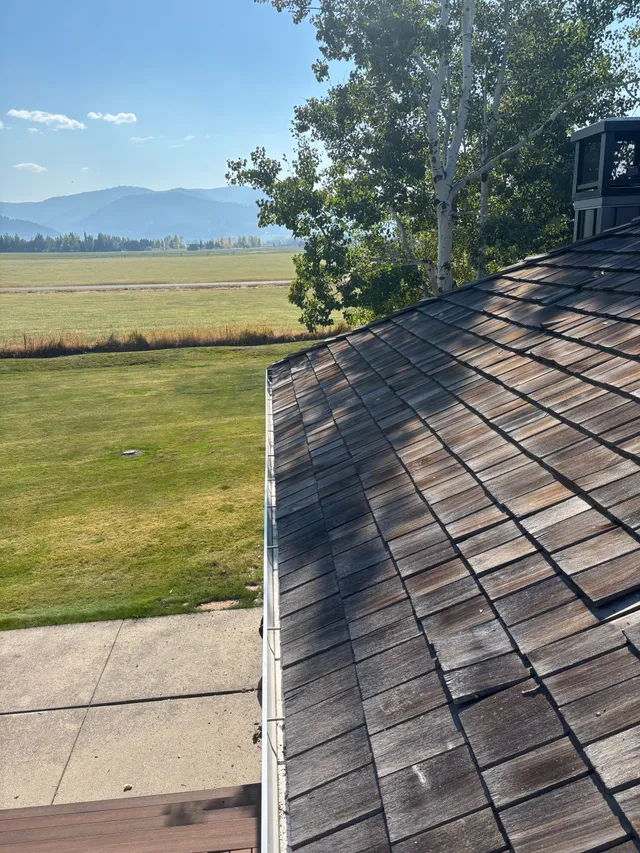 A cedar shake roof with Montana mountains in the distance