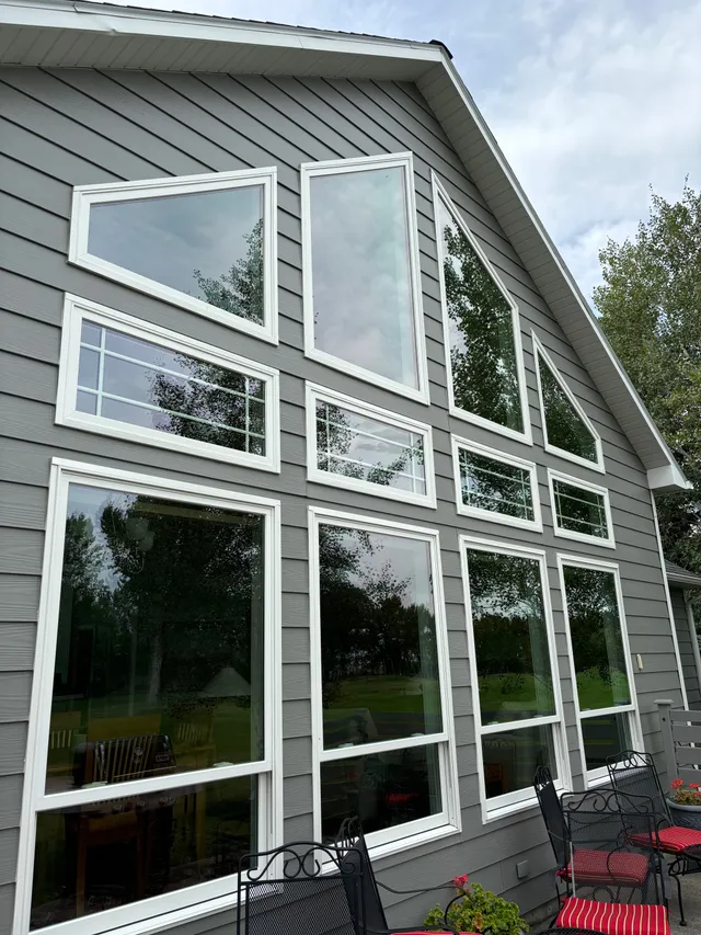 A wall of freshly cleaned windows on a gray house near Bozeman